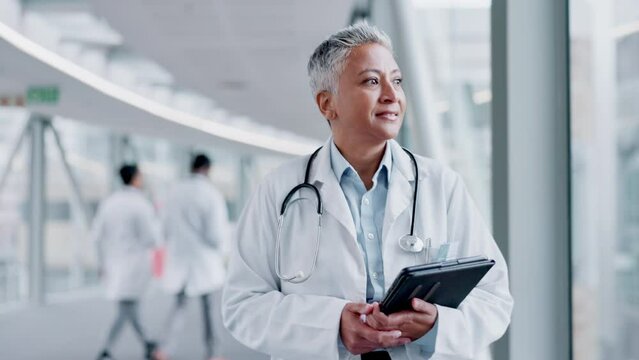 Doctor, walking and a woman greeting in a hospital with tablet for research, results or schedule. Happy medical staff, health care and person with tech in lobby for hello, smile or kindness to people