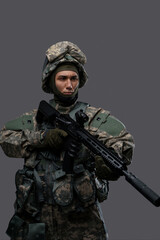 Military man with a gun and a helmet poses ready for action, displaying the discipline and focus of soldiers in uniform