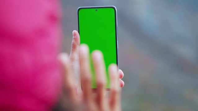 Blank digital smartphone in hand of Asia women, Mobile phone green screen. Woman waving hand saying Hello, Hi. Chroma key, close up Indian woman hand holding phono 