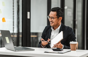 Obraz premium Handsome Asian businessman of Indian descent working at desk, digital asset exchange license, the world's largest cryptocurrency exchange by trading volume, registered recognized market operators