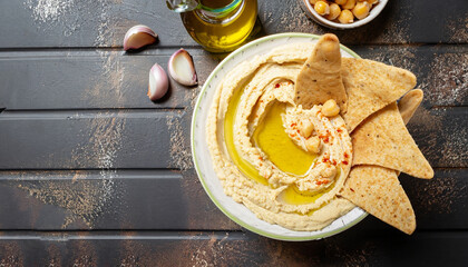 Healthy homemade hummus with olive oil and pita chips. Top view