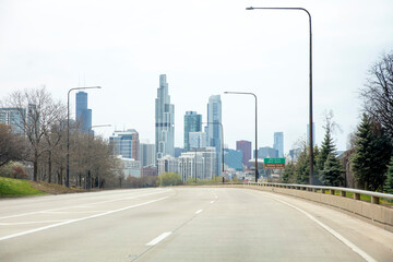 Fototapeta na wymiar Reaching Chicago Illinois USA. Empty urban street, skyscraper building, cloudy sky. Copy space