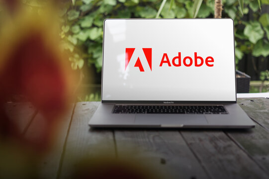 Adobe logo, American multinational computer software company (Adobe Photoshop, Adobe Illustrator, Adobe Acrobat, Adobe Creative Suite, PDF), displayed on a MacBook Pro screen