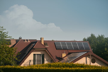 Solar panels on the roof of the modern house. Residential house cottage with blue shiny solar photo...