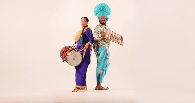 Sikh couple performing bhangra with sapp and drum during Baisakhi Celebration