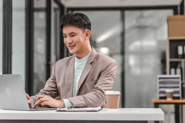 Fototapeta premium Using laptop computer, Asian business asian man supervisor analyse financial report of responsible worker pay attention on mistakes propose correction.