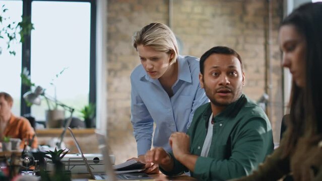 Woman supervisor checking coworkers working in workplace with laptops close up.