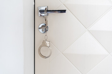 handcuffs hanging from bedroom door handle 