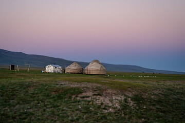 View to yurts in the middle of the mongolian steppe. Capturing the Magic of a Purple Sky at Sunset. The perfect time for landscape photography, the breathtaking colors create - obrazy, fototapety, plakaty