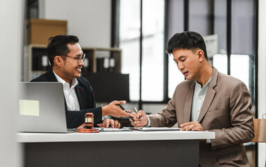 Two disgusting businessmen Asian lawyer of Indian descent paying attention to mistakes, proposing corrections. Businessman discussing contract policy terms with client, rights of liberty concept.