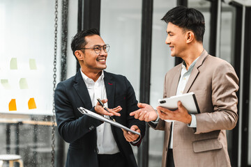 Two disgusting businessmen Asian lawyer of Indian descent paying attention to mistakes, proposing corrections. Businessman discussing contract policy terms with client, rights of liberty concept.