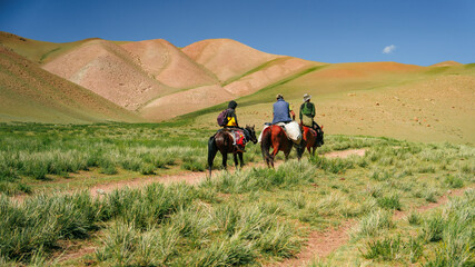 Nomadic couple and their horse in the mountains near Bishkek, Kyrgyzstan. - obrazy, fototapety, plakaty