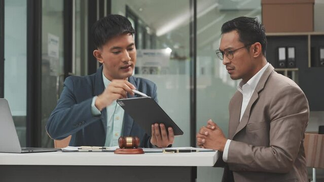 Two disgusting businessmen Asian lawyer of Indian descent paying attention to mistakes, proposing corrections. Businessman discussing contract policy terms with client, rights of liberty concept.