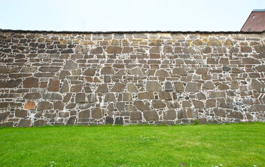 Ancient wall and grass field in front with copy space.. Medieval stone wall of Akershus Castle in Oslo.
