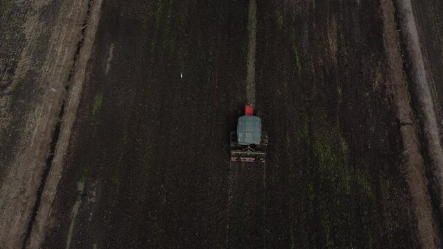 Tractor working in a paddy field aerial top down shot