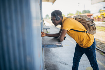 Young man with headphones and mobile phone on the train station