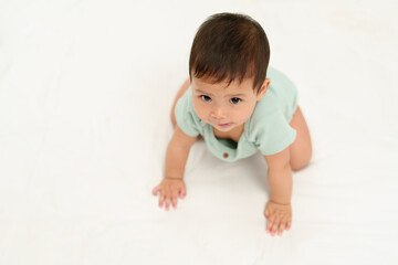 happy infant crawling on floor inside baby playpen