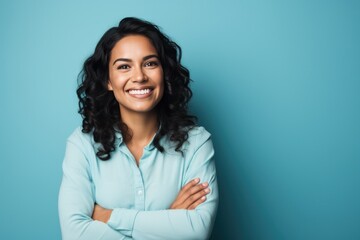 Fototapeta premium Woman posing with arms crossed on blue background