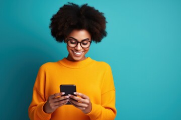 Woman with curly hair is using her smartphone and smiling