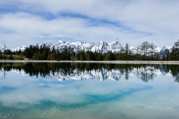 view to a wonderful snowy mountain range with reflections from a lake