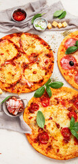 Different types of italian pizza on light background.