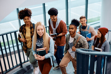 Multiracial group of college students going to lecture together.