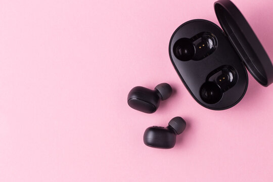 Close-up Black Wireless Headphones On Pink Isolated Background.