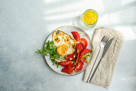 Healthy lunch with fried eggs and tomatoes slices