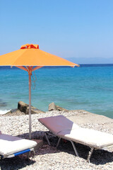 Beautiful blue sea and orange umbrella, Greece
