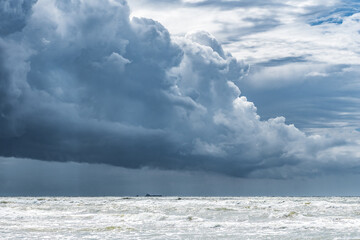 Fototapeta premium Beautiful rough sea with big waves, and dramatic cloudy sky with big dark clouds before the storm and rain