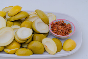 Thai-style pickled mango with chilli-salt, served as a snack, has a sour and salty taste.