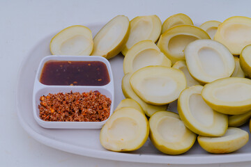 Thai-style pickled mango with chilli-salt, served as a snack, has a sour and salty taste.