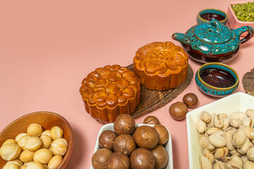 a tasty round moon cakes at mid autumn festival. Flat lay mid autumn festival food and drink on sweet pink background.