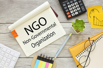top view of notepad with text. orange paper clip NGO Non-Governmental Organization