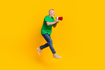 Full size profile portrait of crazy grandfather jump run empty space hold loudspeaker isolated on yellow color background