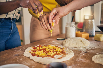 Hands, cheese and pizza for cooking, together and ready for fast food, restaurant or helping with...