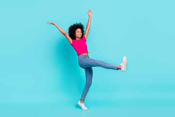 Full body portrait of excited cheerful girl raise hands dancing step walk enjoy free time isolated on turquoise color background