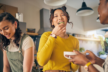 Women, friends and eating healthy food in home for bonding, nutrition and happy lunch together. Fruit diet, sharing and wellness, fresh summer friendship and girls in kitchen with smile at party.