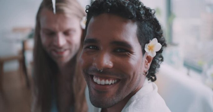 Young queer couple smilling with a jepun flower on their ears. 