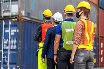 Professional engineer container cargo foreman team in helmets working standing and using walkie talkie checking stock into container for loading.logistic transport and business industry export