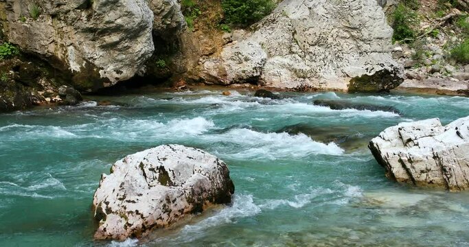 mountain river with azure water flows among large stones. High quality 4k footage
