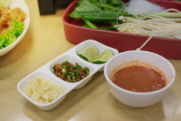 suki sauce in bowl with topping , Chopped chilli, Garlic alley on table ,Thai style food