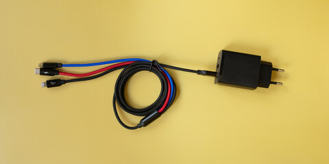 Folded USB lightning cable isolated over the yellow  background. Three types of peripheral...