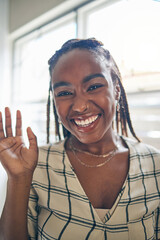 Portrait, wave and black woman on video call, communication and conversation at home. Face, hello and happy person in webinar, virtual chat and online meeting, pov greeting and welcome in remote work © Davids C/peopleimages.com