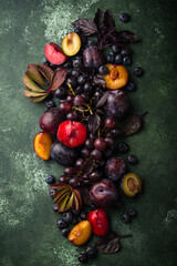 Assortment of purple fruit plum, grape, blueberry and basil