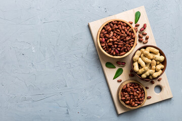 Fresh healthy peanuts in bowl on colored table background. Top view Healthy eating bertholletia concept. Super foods
