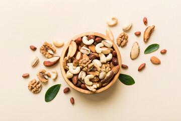 mixed nuts in bowl. Mix of various nuts on colored background. pistachios, cashews, walnuts,...