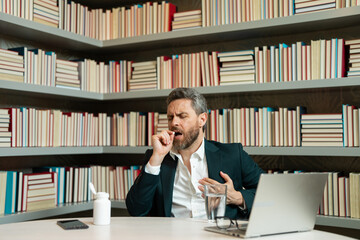 Man taking a medicine pill from headache migraine. Headache and eye strain on laptop. Business man with stress and fatigue eyestrain. Businessman rubbing tired eyes after computer work.