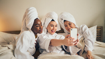Spa day, selfie and friends in bed relax with social media during skincare routine at home. Bedroom, self care and women beauty influencer with smartphone smile for profile picture, blog or podcast