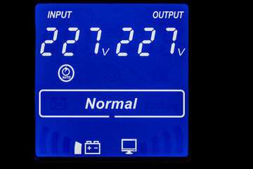 Closeup of blue digital display on uninterruptible power supply with automatic voltage stabilizer
